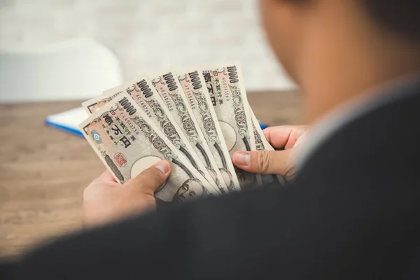 Empresário contando dinheiro, contas de iene japonês - visão traseira — Fotografia de Stock