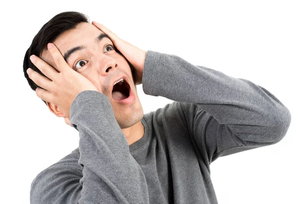 Mladý muž vyjadřující šokován tváře s rukou na jeho hlavy — Stock fotografie