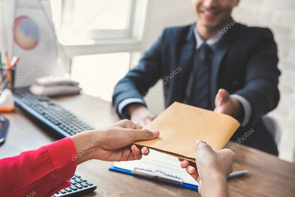 Businessman receiving envelope (money) from a woman while making