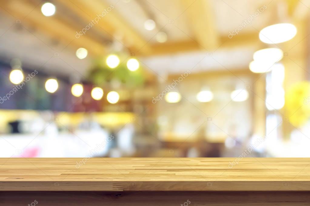 Wood table top on blur cafe interior background