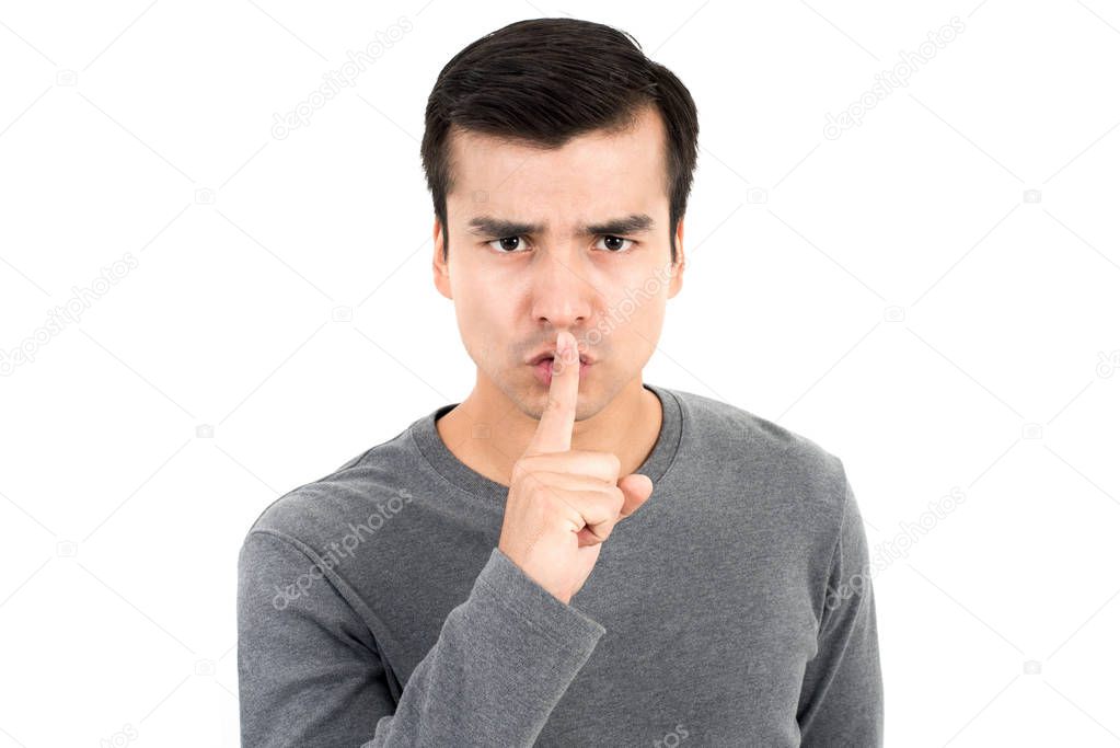 Young man making hush (shh) gesture