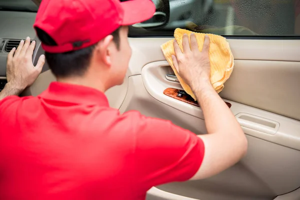 Un hombre limpiando el panel de la puerta del coche con tela de microfibra — Foto de Stock