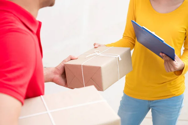 Entrega homem dando caixa de pacote para uma mulher — Fotografia de Stock