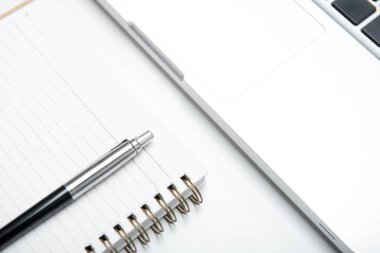 Defter ve kalem beyaz masada dizüstü bilgisayarınızla