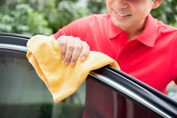 Un hombre limpiando la puerta del coche — Foto de Stock