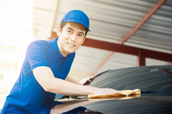 A man polishing (cleaning) car in the garage — Stock Photo, Image