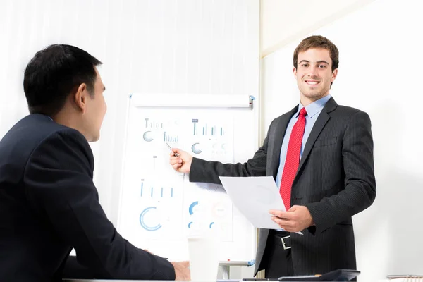 Jonge zakenman presentatie van grafieken in de vergadering — Stockfoto