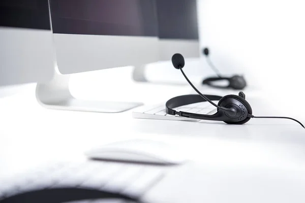 Microphone headsets on the table with computer keywords — Stock Photo, Image