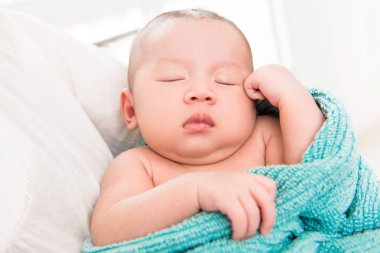 Sevimli küçük yeni doğan bebek annenin kollarına uyku