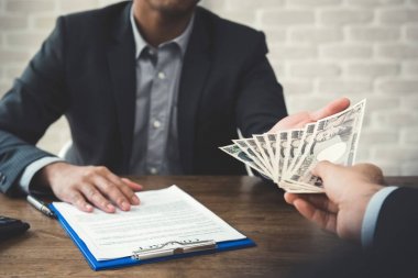 Bir sözleşme yaparken ortağı için para veren işadamı