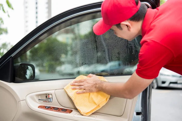 Um homem limpando a porta do carro painel interior — Fotografia de Stock