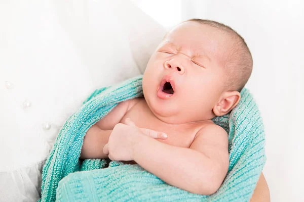Cute newborn baby yawning while sleeping in the arms of mother — Stock Photo, Image