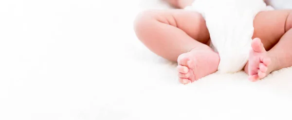 Baby legs and feet on white wool fluff sheet - web banner with c — Stock Photo, Image