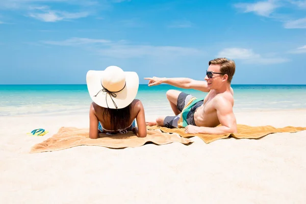 Pareja acostada en la playa tomando un baño de sol en verano —  Fotos de Stock