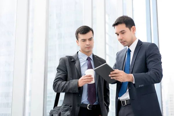 Ondernemers kijken naar tablet pc bespreken werk in office — Stockfoto