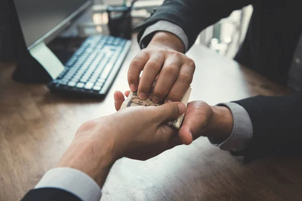 Empresario poniendo dinero en su mano de socio —  Fotos de Stock