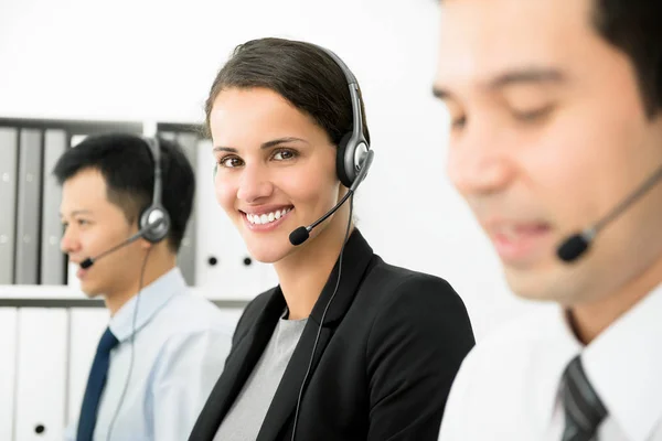 Smiling businesswoman working in call center as a telemarketer — Stock Photo, Image