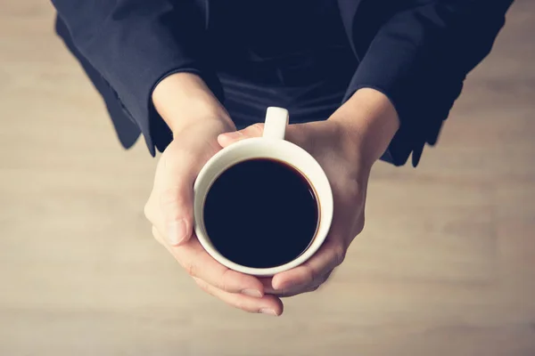 Manos de mujer sosteniendo taza de café con café negro —  Fotos de Stock