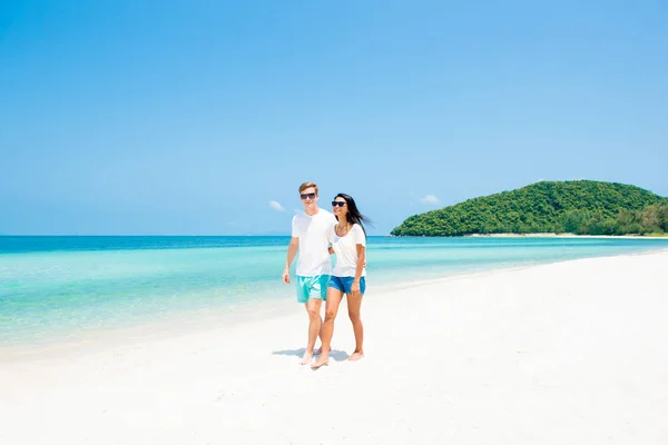 Interracial pareja caminando en hermosa playa en verano —  Fotos de Stock