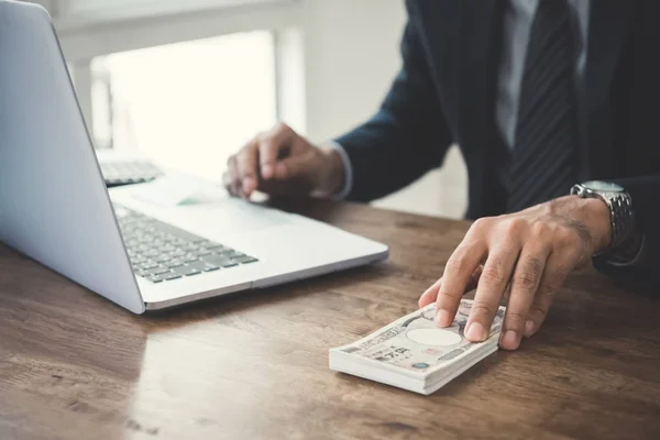 Empresario dando dinero sobre la mesa, billetes en yenes japoneses —  Fotos de Stock