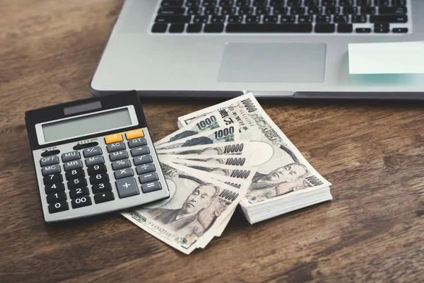 Dinero, billetes de yen japoneses, con calculadora y computadora portátil —  Fotos de Stock