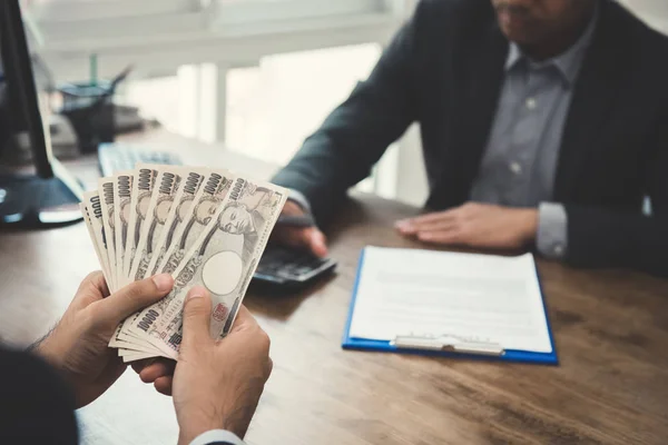 Empresário contando dinheiro, notas de iene japonês, enquanto faz — Fotografia de Stock