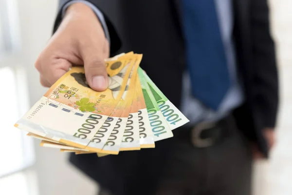 Geschäftsmann gibt Geld, südkoreanische Won-Rechnungen — Stockfoto