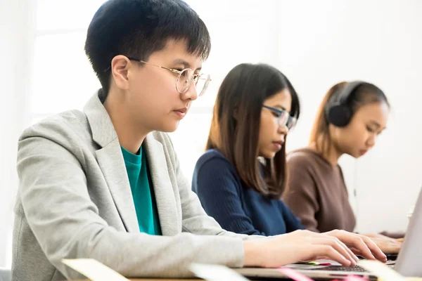 Estudiantes asiáticos universitarios se concentran en el uso de computadoras portátiles — Foto de Stock