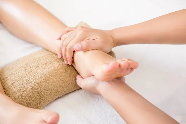 Therapist giving traditional thai foot massage to a woman — Stock Photo, Image