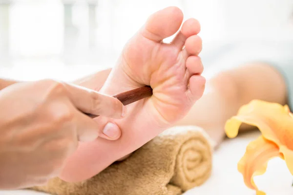 Professionelle Therapeutin gibt traditionelle thailändische Fußmassage mit — Stockfoto
