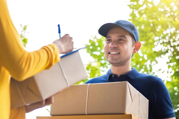 Lächelnder Zusteller liefert Paketkästen an Frau aus — Stockfoto