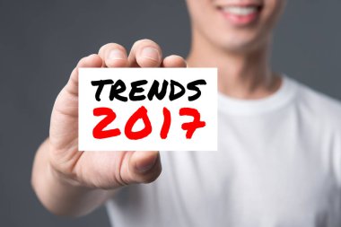 Genç adam tarafından gösterilen kartta 2017 TREND mesajı