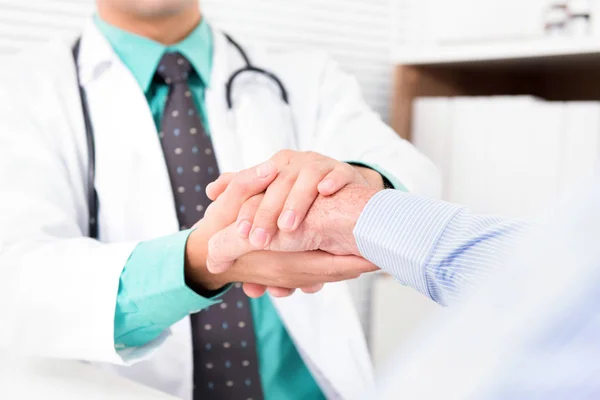 Arzt hält älteren männlichen Patienten die Hand — Stockfoto