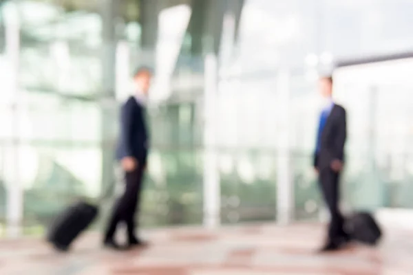 Blur businessmen with luggage at the airport