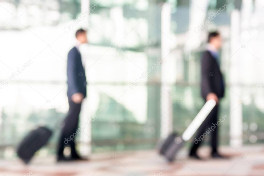 Blur businessmen with luggage at the airport
