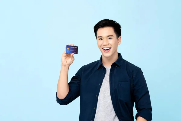 Szczęśliwy Przystojny Młody Azji Człowiek Pokazując Karty Kredytowe Odizolowane Jasnoniebieski — Zdjęcie stockowe