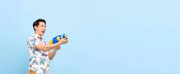 Sonriente Hombre Asiático Guapo Jugando Con Pistola Agua Aislado Fondo —  Fotos de Stock