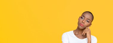 Afro-Amerikalı kadın, sarı izole edilmiş stüdyo afişlerinde sıkılmış hissediyor.