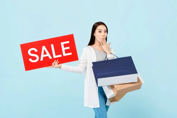Överraskad Vacker Asiatisk Kvinna Med Shoppingväskor Visar Röd Försäljning Tecken — Stockfoto