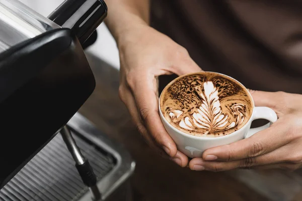 カフェラテを持っているバリスタの手がカフェで提供しようとしています — ストック写真