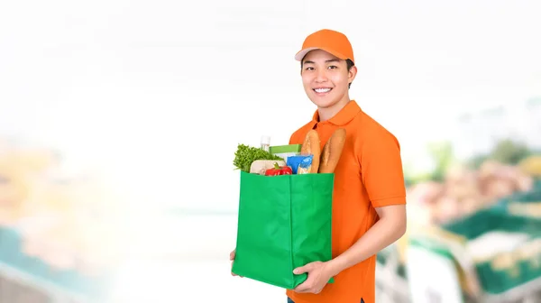 Hijyenik Gülümseyen Asyalı Teslimatçı Market Arka Planında Alışveriş Çantası Taşıyor — Stok fotoğraf
