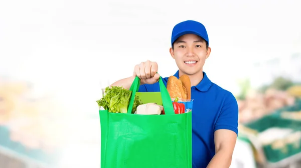 Lächelnder Asiatischer Mann Hält Einkaufstüte Supermarkt Und Bietet Lieferservice Nach — Stockfoto