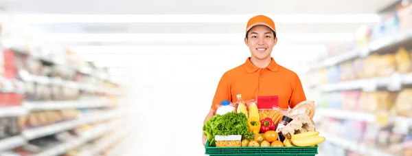 Higiénico Sonriente Asiático Repartidor Llevando Caja Bandeja Supermercado Banner Fondo — Foto de Stock