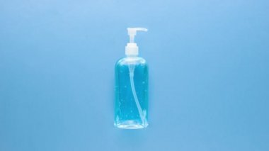 COVID-19 'dan korumak için çeşitli tıbbi malzemeler maske, alkol jeli ve eldivenler dahil. açık mavi arkaplanda