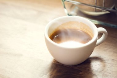 Sıcak bir fincan espresso. Kahvaltı için ahşap masada kahve.
