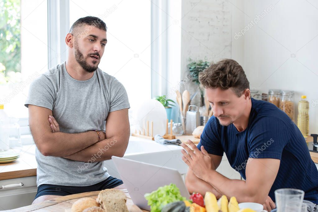 Mature caucasian gay male couple having an arguement while having breakfast in the morning at home