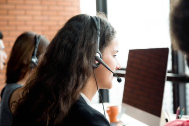 Telepazarlama merkezinde çalışan mikrofon takan iş kadınlarının arka plan görüntüsü