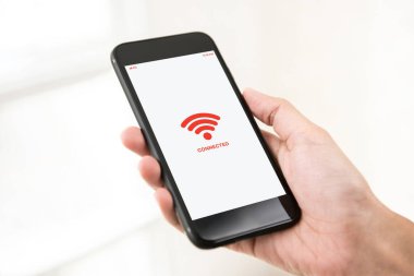 Beyaz arka planda ücretsiz kablosuz görüntülü siyah bir cep telefonu tutan bir erkek.