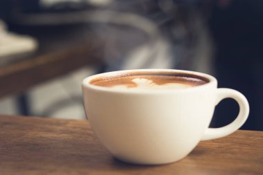 Tahta masadaki fincanda taze demlenmiş kahve içmeye hazır.