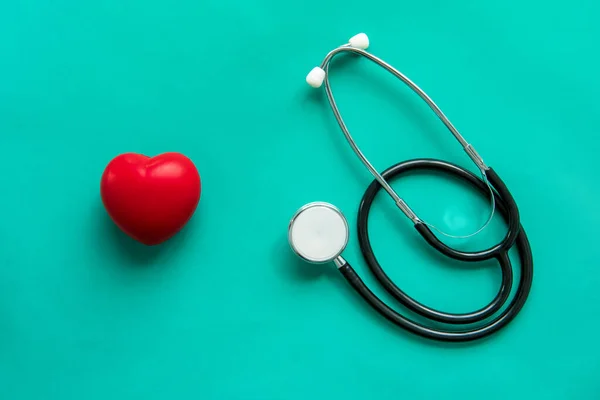 Rode Hartvormige Bal Met Stethoscoop Groene Achtergrond Gezondheidszorg Medisch Concept — Stockfoto